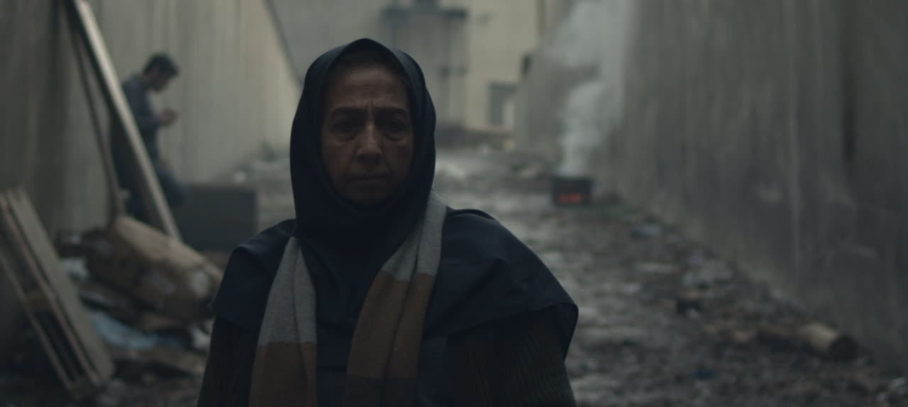 A hooded woman in the ruins of an abandoned factory