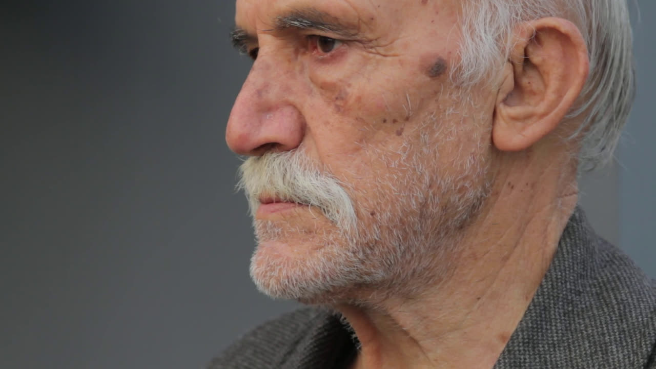 Close-up of an older man with a white moustache